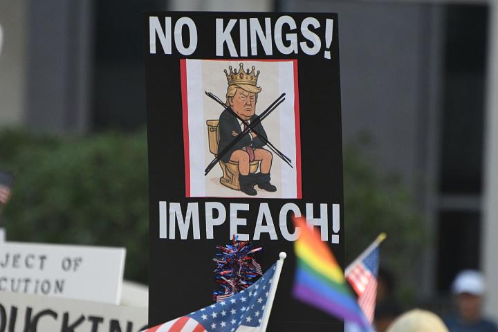 Manifestantes en Orlando (Florida), sostienen banderas y corean el lema "Sin rey" contra Donald Trump, el 18 de octubre de 2025.