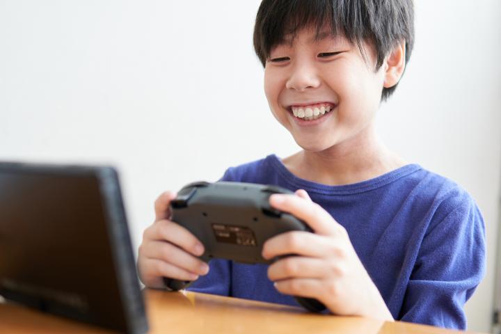 Niño japonés jugando un videojuego.