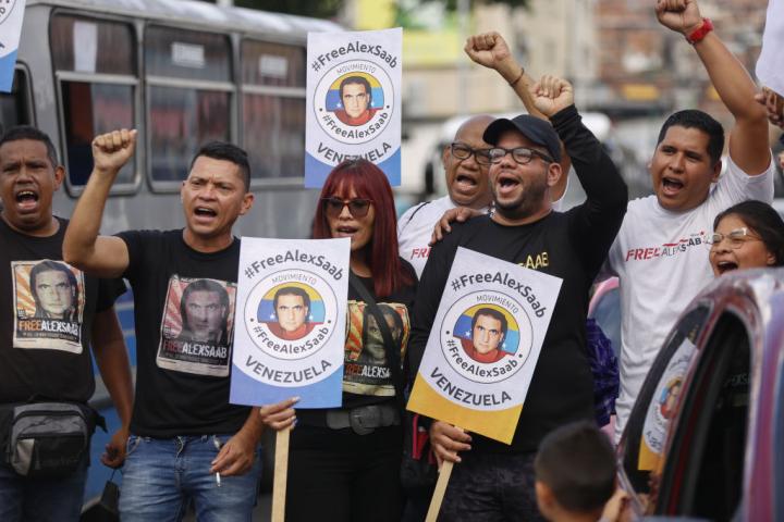 Manifestantes sostienen fotos del empresario colombiano Alex Saab durante una protesta para pedir su libertad, en la zona de Petare, Caracas, el 18 de agosto de 2022.