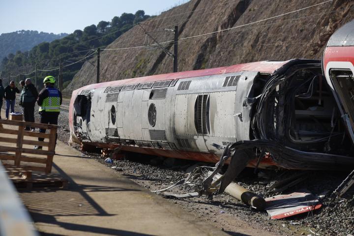 Operarios junto aun vagón del tren Iryio siniestrado en el accidente ferroviario ocurrido el pasado domingo.