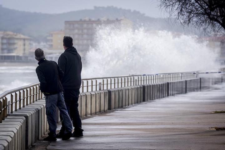 Unas personas observan la subida de las olas por el temporal en la costa de Girona, el 19 de enero de 2026.