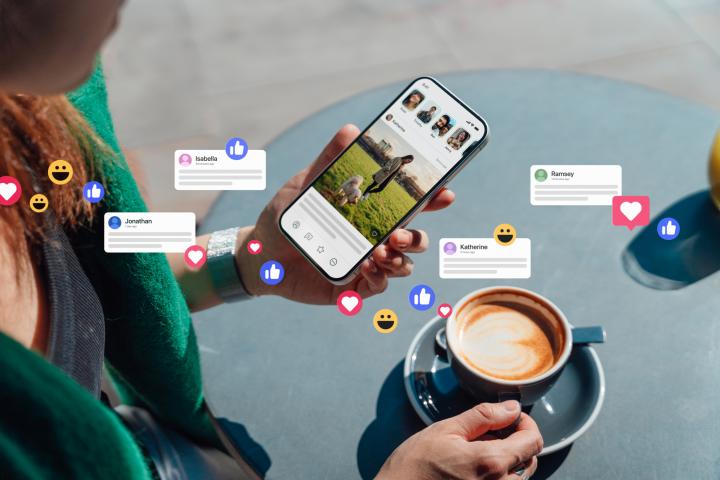 Primer plano de una mujer sosteniendo un smartphone, conectándose a redes sociales, dejando comentarios, enviando mensajes y compartiendo fotos. La tecnología conecta a las personas.