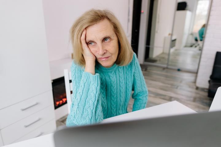 Una pensionista mayor revisa documentación relacionada con prestaciones de jubilación.