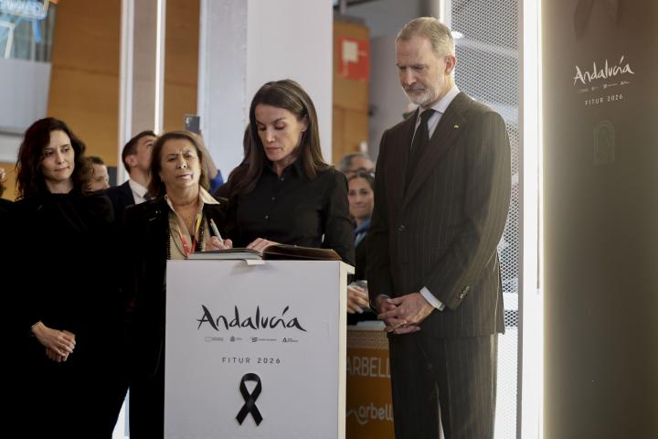 Letizia firmando el libro de condolencias tras el accidente ferroviario de Adamuz y Felipe, a su lado, con los manos cruzadas.