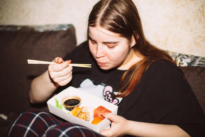 Una joven come sushi en casa.