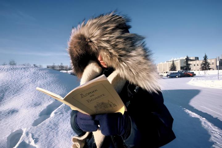 Joven estudiante en Alaska con un abrigo grande con capucha de pelo