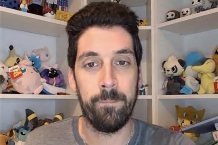 Enfermero español que vive en Noruega habla a cámara en su casa mientras explica su experiencia laboral en un pueblo aislado.