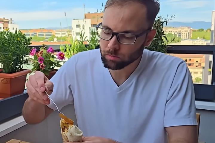 Bruce, estadounidense, desayunando en la terraza de su piso en Logroño.