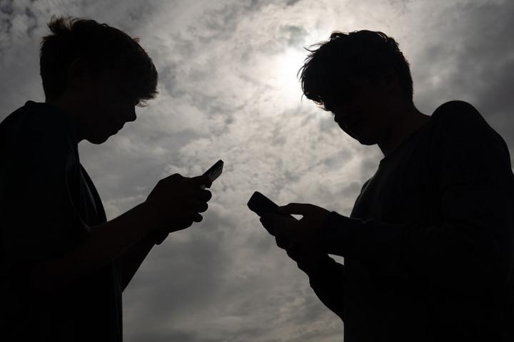 Adolescentes usando teléfonos móviles, imagen relacionada con el debate en Francia sobre la prohibición de redes sociales a menores de 15 años.
