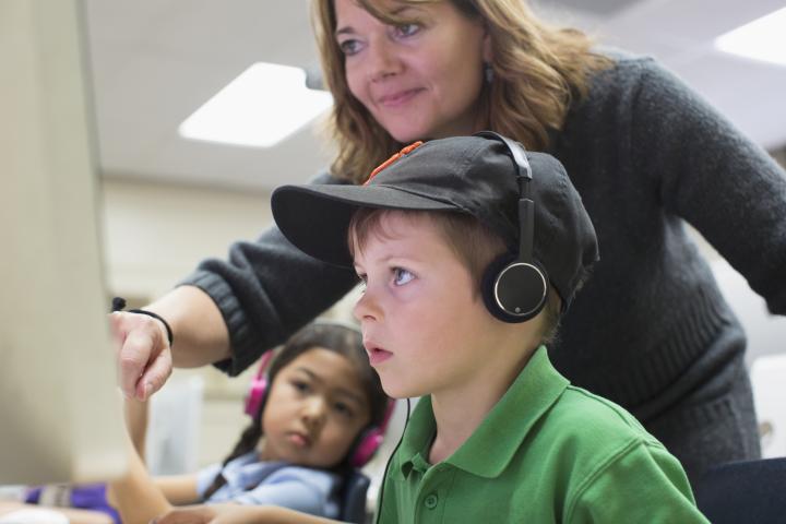 Una profesora enseñando a uno de sus alumnos.