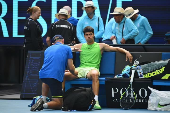 Carlos Alcaraz siendo atendido por calambres en las semis del Open de Austrlia