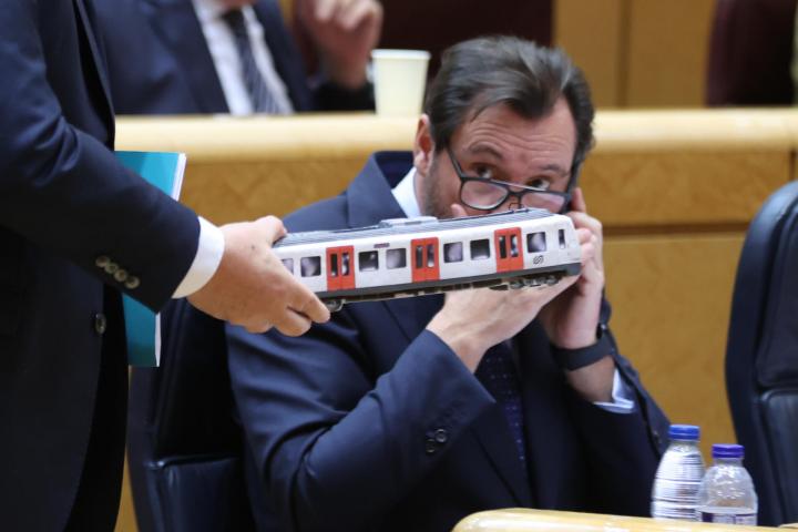 El ministro de Transportes, Óscar Puente, observa una maqueta de un vagón de tren que le muestra el senador de Junts Eduard Pujol