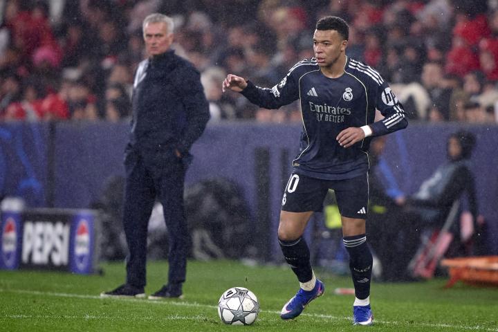 Mbappé encara a un jugador del Benfica durante el partido en Lisboa con Mourinho mirando de cerca