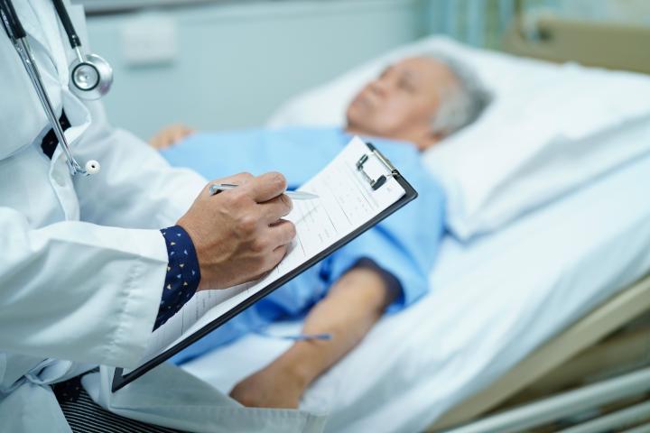 alt="alt="Médico escribiendo el diagnóstico en el portapapeles mientras que la anciana de edad avanzada asiática o anciana acostada en la cama en la sala del hospital de enfermería : concepto médico fuerte saludable.""