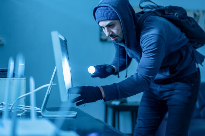 Un ladrón robando un ordenador.
