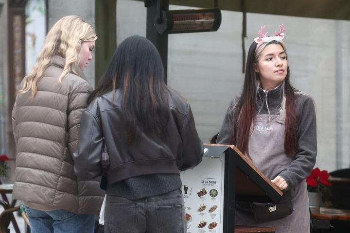 Una camarera, atendiendo a clientes en una terraza de Madrid, el 19 de diciembre de 2025.