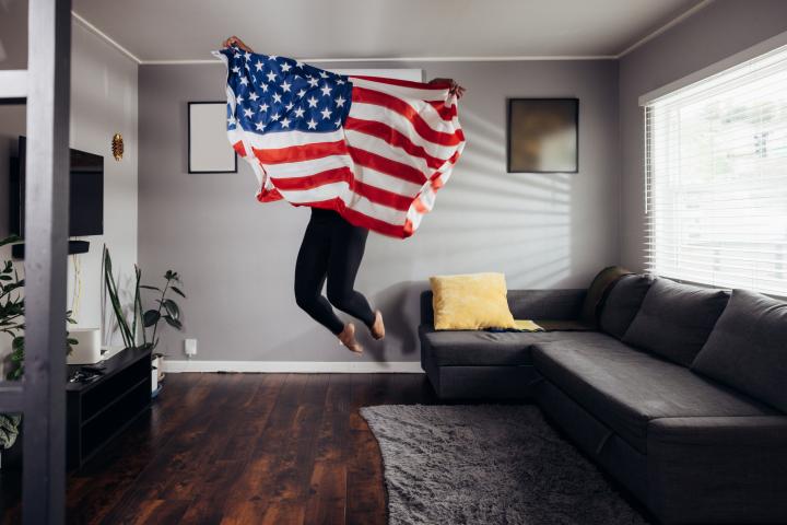 Una persona, saltando con la bandera de EEUU.
