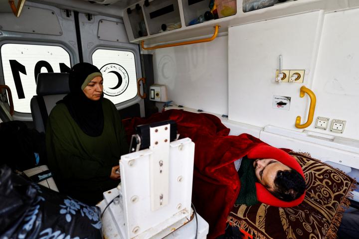 Un paciente palestino yace dentro de una ambulancia, acompañado por un familiar, mientras intenta regresar a su casa en el norte de Gaza, el 4 de febrero de 2026.