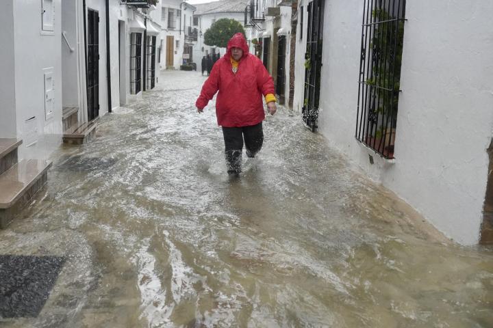 GRAZALEMA (CÁDIZ), 04/02/2026.- Un vecino de Grazalema (Cádiz) camina por una calle inundada debido a las intensas lluvias que se registran este miércoles en la localidad gaditana, que acumula 238,3 litros por metro cuadrado y que suceden al mes de enero más lluvioso desde principios del siglo XX en la localidad. EFE/Román Ríos.