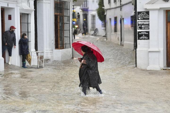Una vecina de Grazalema (Cádiz) camina por una calle inundada debido a las intensas lluvias durante el paso de la borrasca Leonardo, el 4 de febrero de 2026.