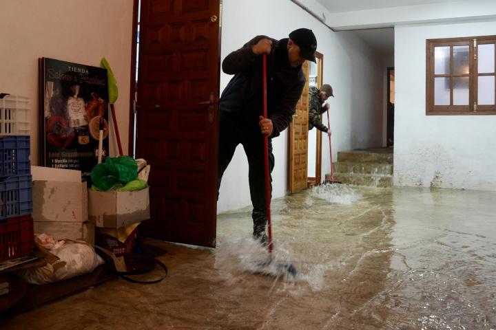 Vecinos de Grazalema (Cádiz) intentan achicar agua de sus casa y locales tras las intensas lluvias del 4 de febrero de 2026.