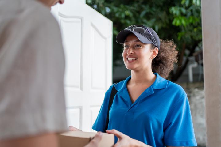 Una joven repartiendo un paquete, en una imagen de archivo.