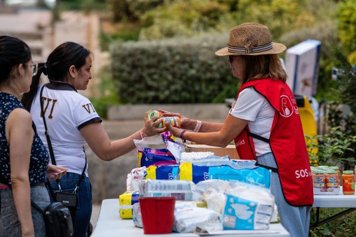 Una mujer recibe comida donada en la Fundación Madrina.