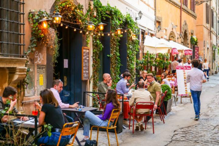 alt="alt="Rome, Italy, May 22 -- Some persons sitting outside a bar enjoy an aperitif in Trastevere in Rome during the slow reopening to a normal life after the lockdown due to the Covid-19. Image in HD format.""