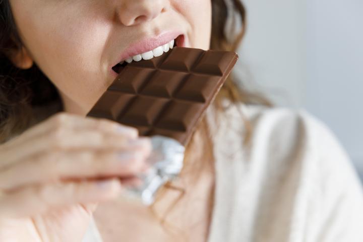 Mujer comiendo chocolate.