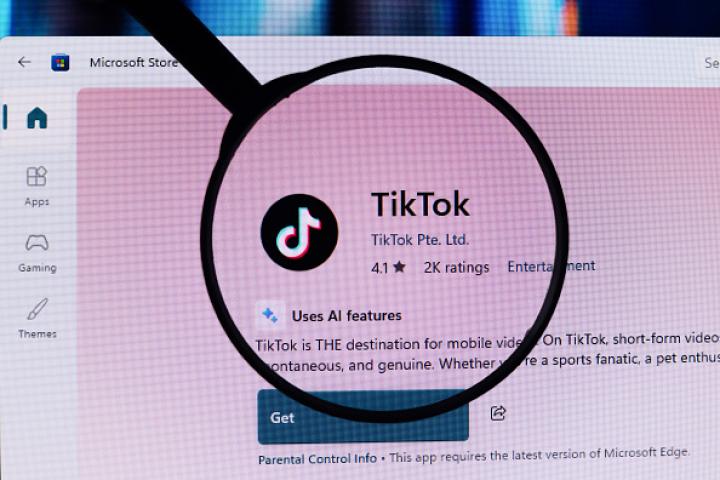 The TikTok logo is displayed through a magnifying glass in the Microsoft app store, in this photo illustration in Ontario, Canada, on February 2, 2026 (Photo Illustration by Thomas Fuller/NurPhoto via Getty Images).