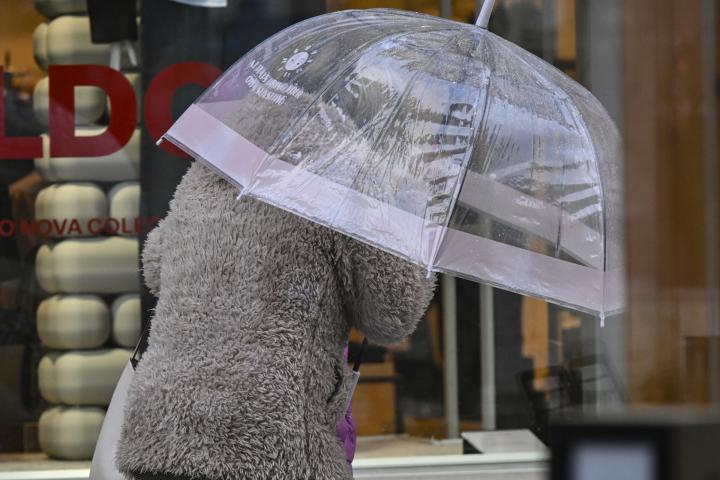 Una mujer se protege de las fuertes lluvias.