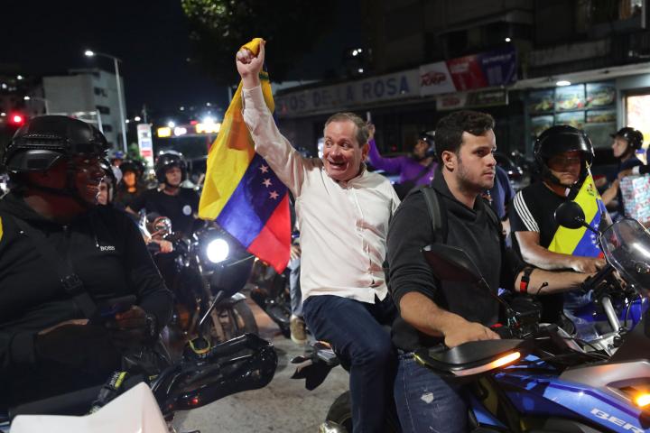 El opositor Juan Pablo Guanipa sostiene una bandera de Venezuela en una manifestación este domingo, en Caracas (Venezuela), tras su liberación.