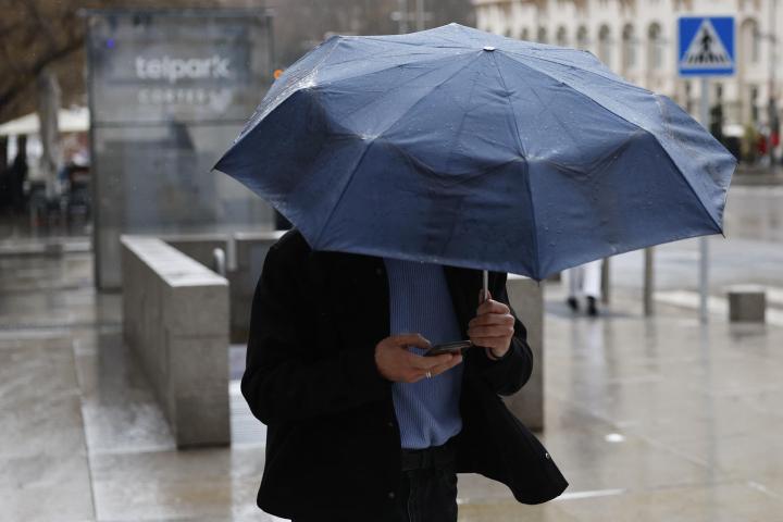 Un hombre se protege de la lluvia este viernes en Madrid