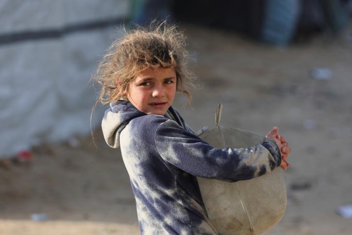 Un niño sostiene un contenedor en una zona con tiendas de campaña para refugiados, en ciudad de Gaza, el 2 de febrero de 2026.