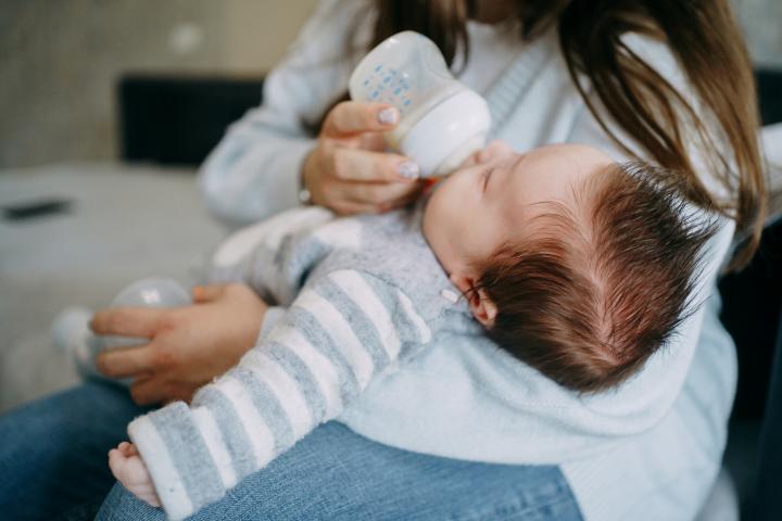 Una mujer da el biberón a su bebé