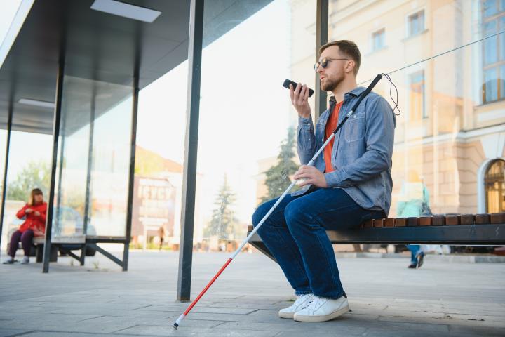 Una persona invidente esperando en una estación de tren