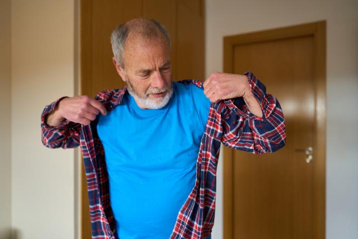 Un jubilado, vistiéndole, en una imagen de archivo.