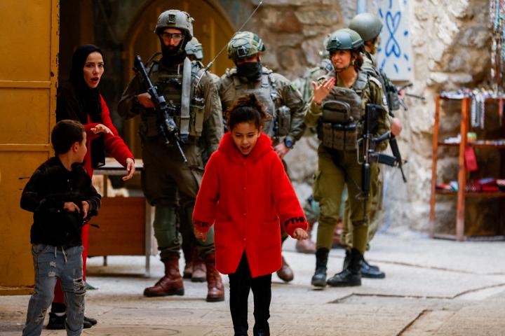 Una mujer palestina aleja a sus hijos de un grupo de soldados israelíes en Hebrón, en la Cisjordania ocupada por Israel, el 24 de enero de 2026.