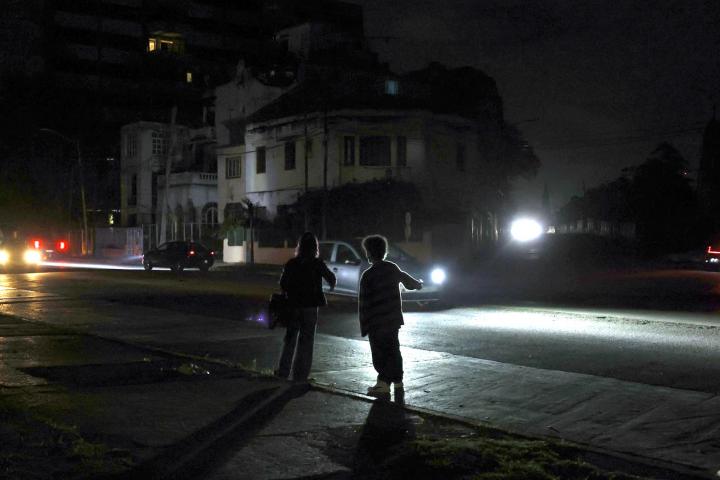 Unos vecinos intentan conseguir transporte en una calle oscura por los apagones, el 15 de enero de 2026, en La Habana (Cuba).