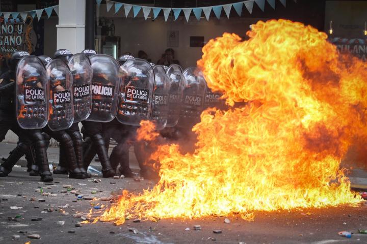 Integrantes de la Policía de Argentina se cubren durante un enfrentamiento con manifestantes contra la reforma laboral de Javier Milei, el 11 de febrero de 2026, en Buenos Aires.