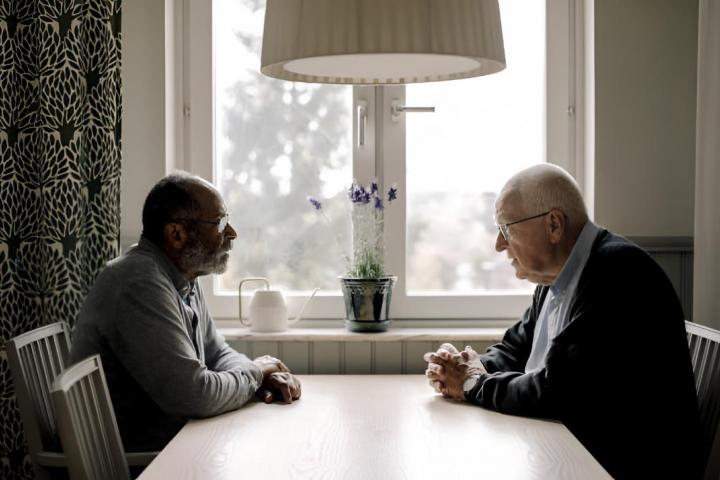 Dos hombres mayores hablando en la mesa en un hogar de ancianos