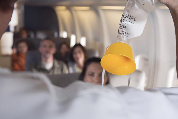 Un azafato de vuelo mostrando la máscara de oxígeno del avión