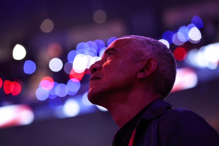 Barack Obama mirando hacia arriba (¿buscando aliens?) en un partido de la NBA