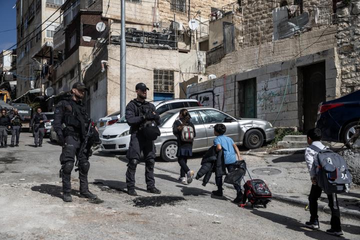 Soldados israelíes vigilan una demolición de una vivienda palestina en el barrio de Silwan, en Jerusalén en la parte de la Cisjordania ocupada, mientras pasan varios escolares palestinos.