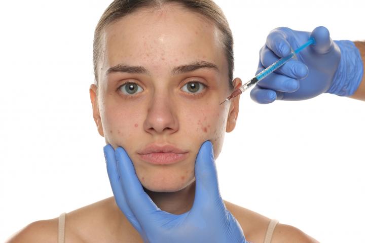 Una adolescente inyectándose un tratamiento facial.