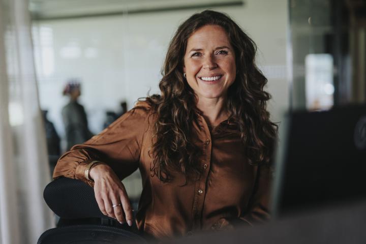 Retrato de una feliz empresaria madura con cabello castaño en la oficina