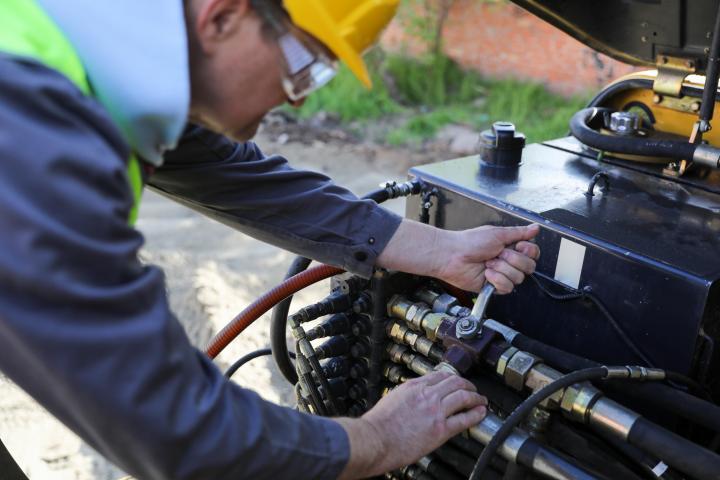 Un hombre arreglando su excavadora, en una imagen de archivo.