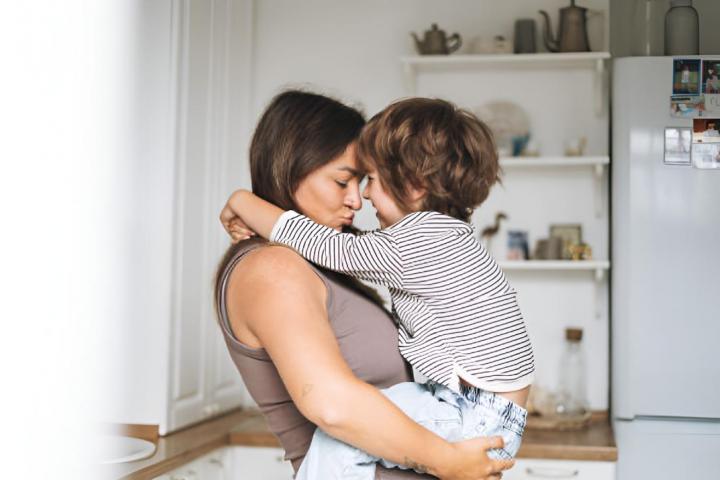Una madre y su hijo pequeño abrazándose con cariño