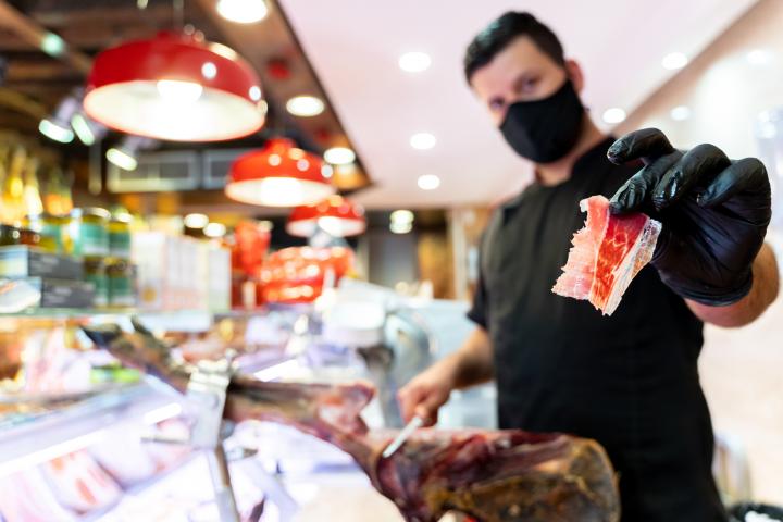 Un carnicero corta jamón