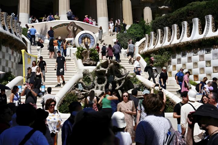 Una masificación de turistas visitando la escalera monumental del Parque Güell de Barcelona